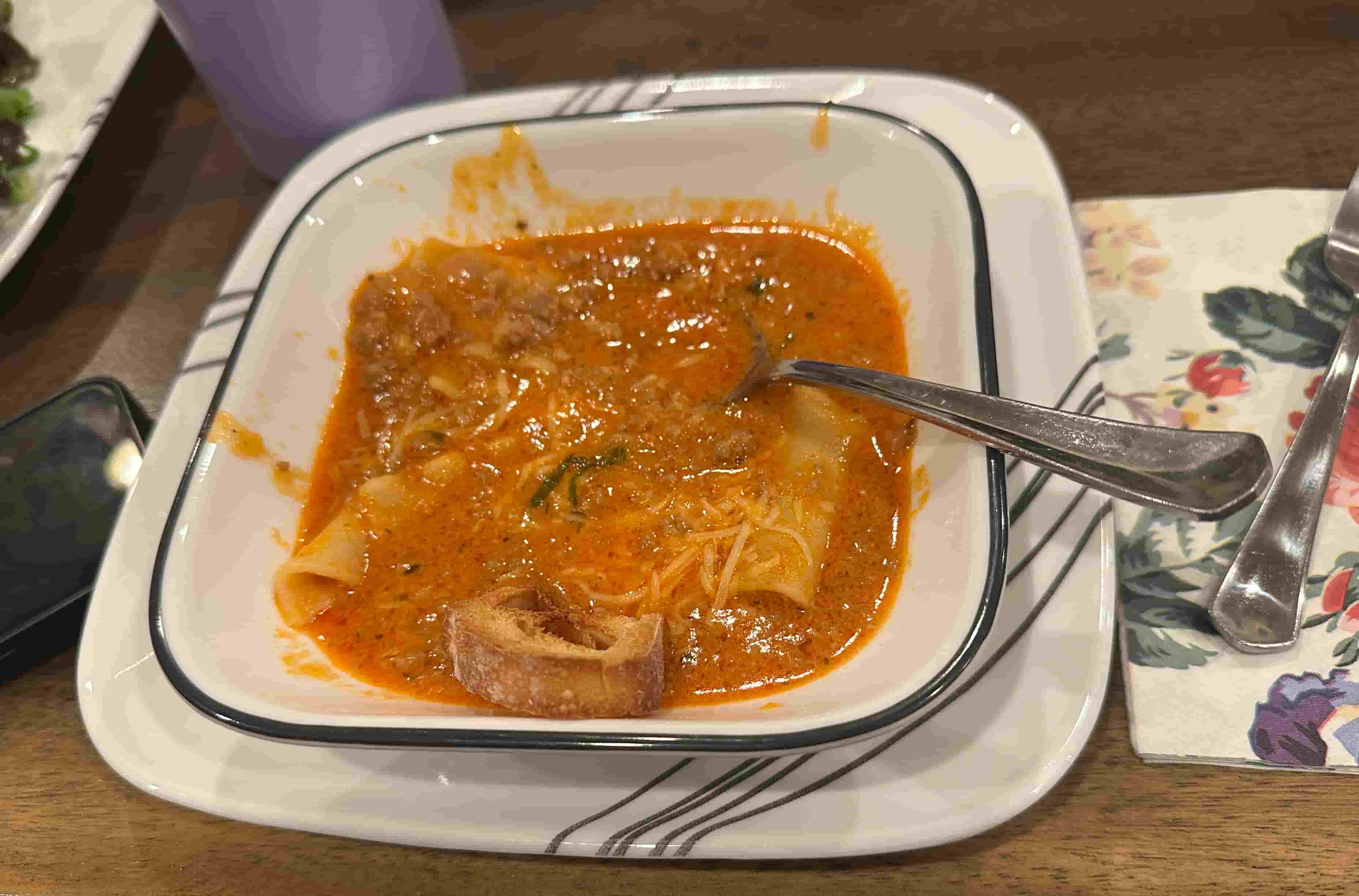 Bowl of Lasagna Soup with cheese and bread.